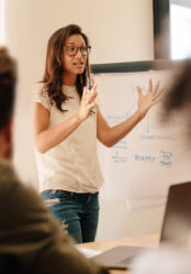 Businesswoman explaining new plan to colleagues in conference room. Businesspeople during meeting in office board room.