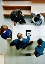 Overhead view of business colleagues discussing project on digital tablet